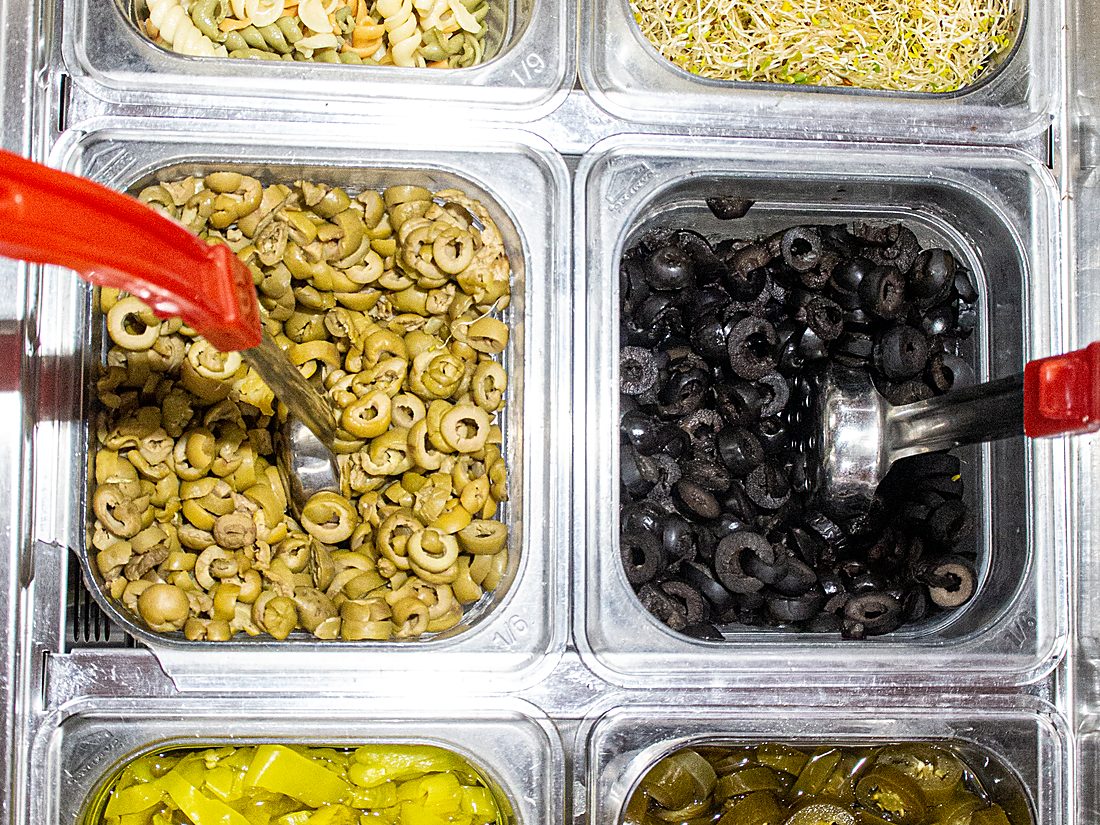 Aceitunas, pepperoncini y jalapeños en la barra fría de City Salads